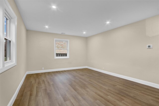 empty room featuring baseboards, recessed lighting, and wood finished floors