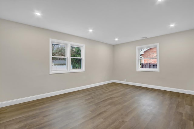 empty room featuring baseboards, recessed lighting, and wood finished floors
