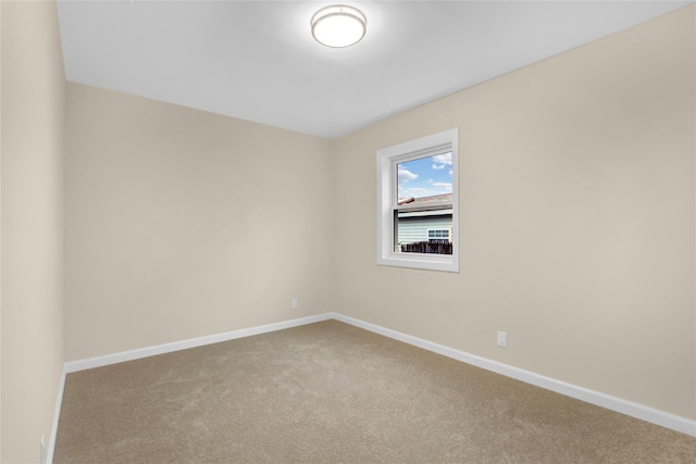 carpeted empty room featuring baseboards