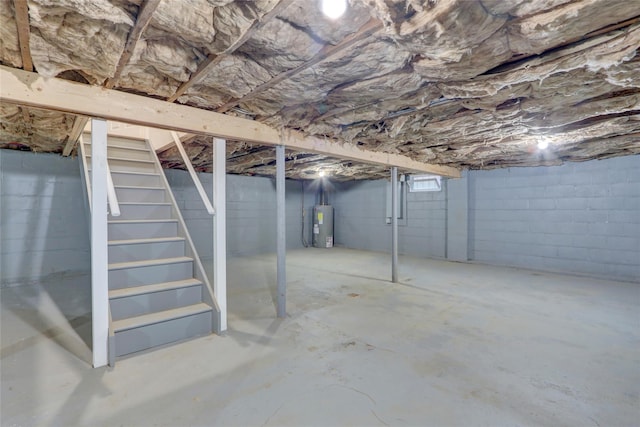 unfinished basement with stairs and water heater