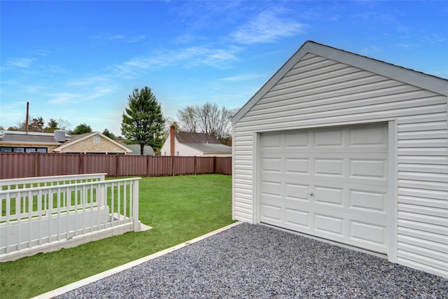 detached garage with fence and gravel driveway