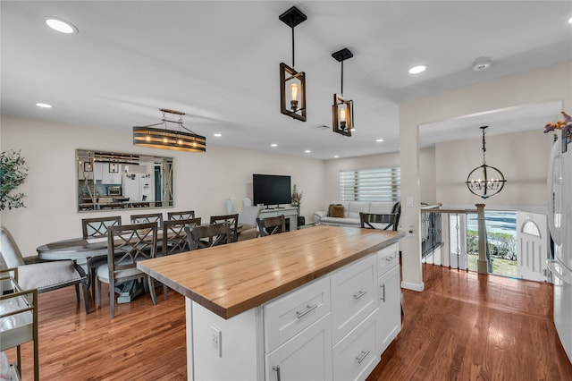 kitchen with butcher block counters, white cabinetry, a chandelier, and dark wood-style flooring