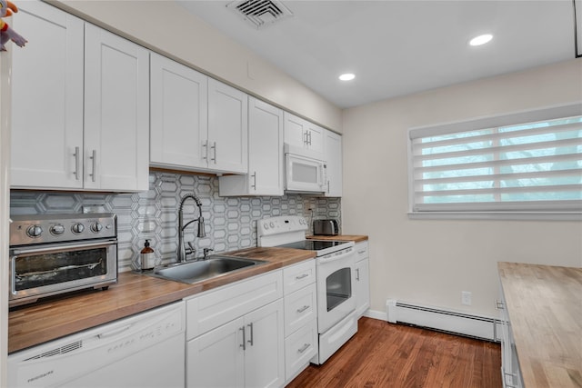 kitchen featuring a sink, a baseboard radiator, visible vents, butcher block countertops, and white appliances