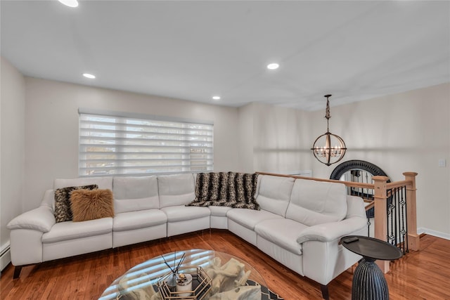 living room with recessed lighting, baseboard heating, wood finished floors, and a chandelier