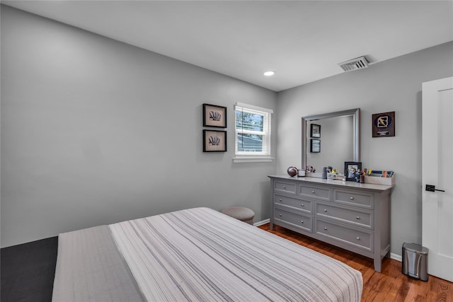 bedroom featuring baseboards, visible vents, wood finished floors, and recessed lighting