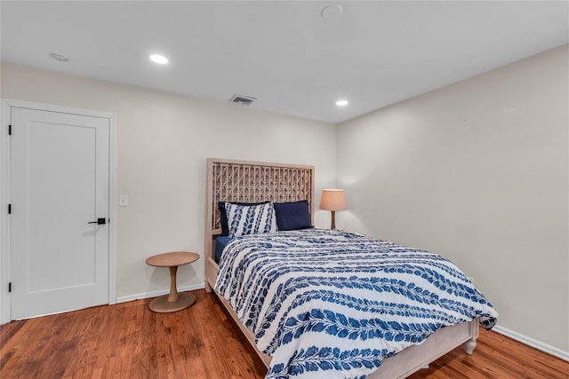 bedroom with baseboards, visible vents, wood finished floors, and recessed lighting