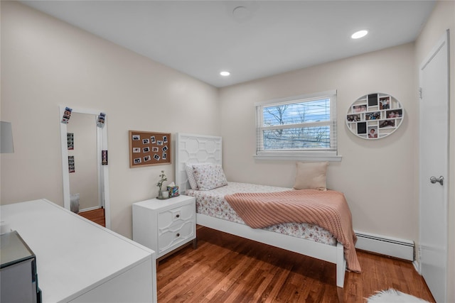 bedroom featuring baseboards, recessed lighting, wood finished floors, and a baseboard heating unit