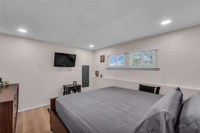 bedroom featuring electric panel, recessed lighting, light wood finished floors, and baseboards