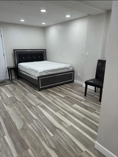 bedroom with baseboards, recessed lighting, and wood finished floors
