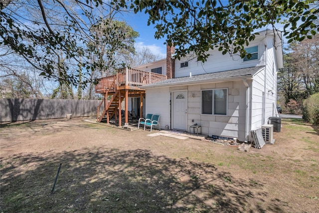 rear view of house with a chimney, stairway, fence, and a wooden deck