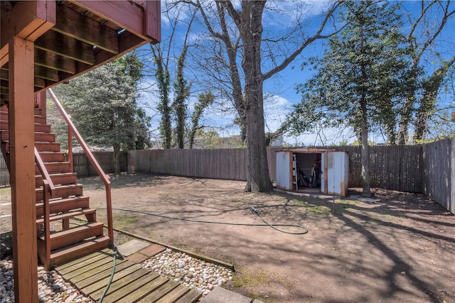 view of patio / terrace featuring stairs, a shed, and a fenced backyard