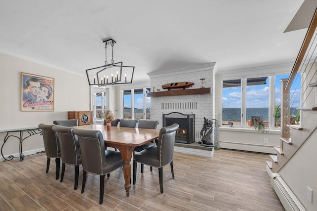 dining space featuring baseboards, a baseboard radiator, baseboard heating, a fireplace, and ornamental molding