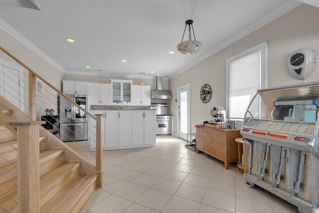 kitchen with white cabinets, stainless steel appliances, wall chimney range hood, light tile patterned floors, and glass insert cabinets