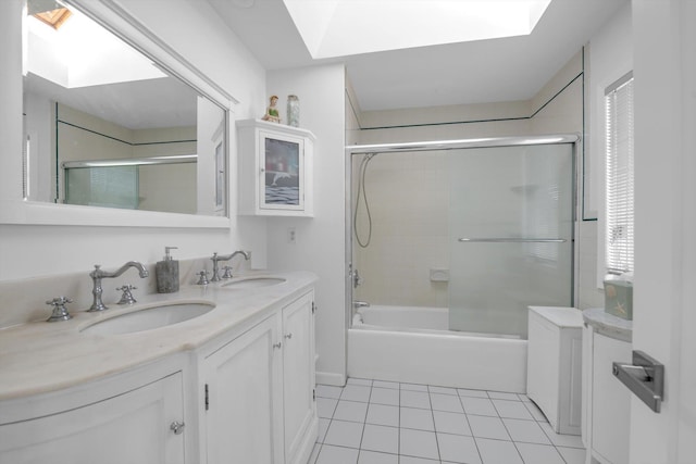 bathroom with a skylight, tile patterned floors, a sink, and shower / bath combination with glass door