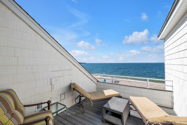 balcony featuring a view of the beach and a water view