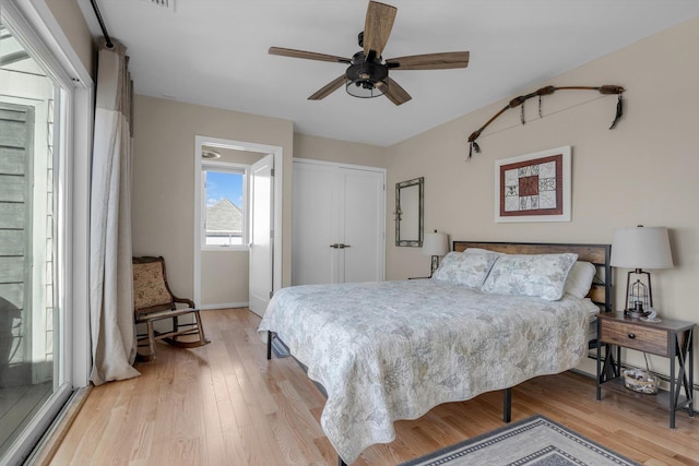 bedroom with light wood-style floors, a closet, a ceiling fan, and baseboards