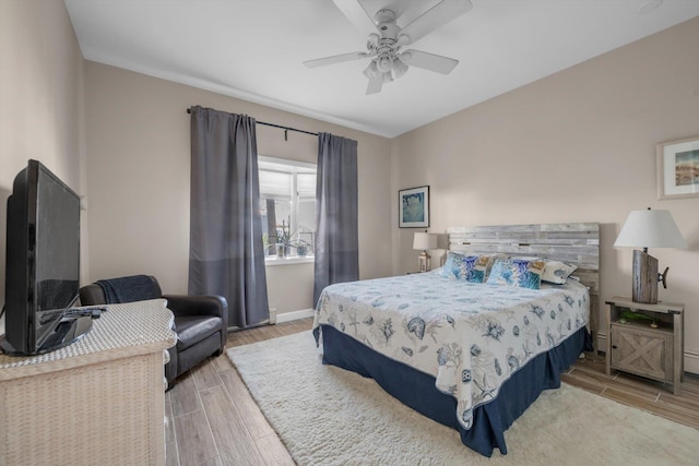 bedroom with baseboards, a ceiling fan, and wood finished floors