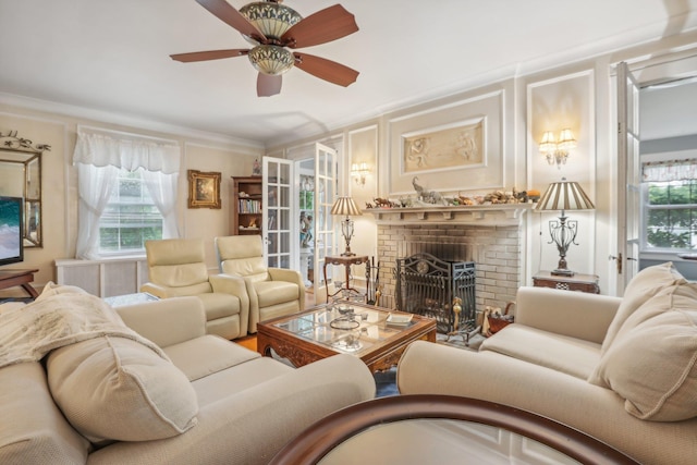 living area featuring a decorative wall, ceiling fan, ornamental molding, and a fireplace