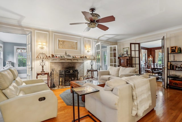 living area with plenty of natural light, crown molding, light wood-style flooring, and ceiling fan