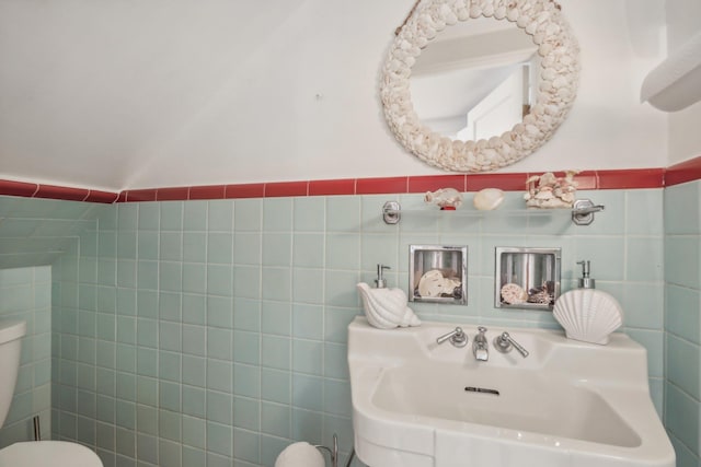 bathroom featuring toilet and tile walls