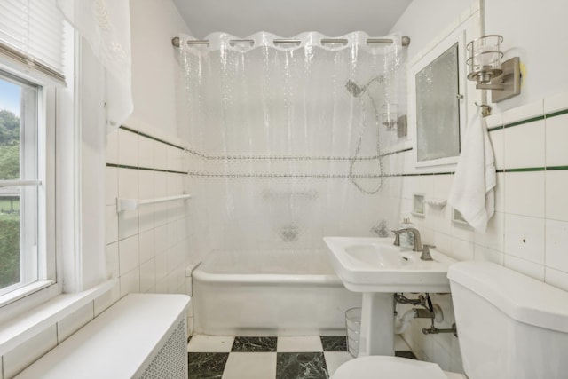 full bath featuring toilet, shower / bath combination, and tile walls