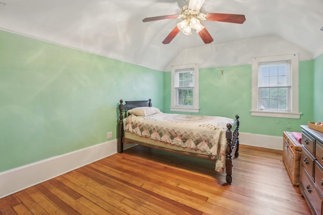 bedroom featuring baseboards, light wood-style flooring, ceiling fan, and lofted ceiling