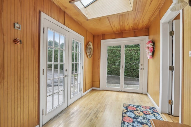doorway to outside with wood ceiling, french doors, a skylight, wood walls, and light wood-style floors