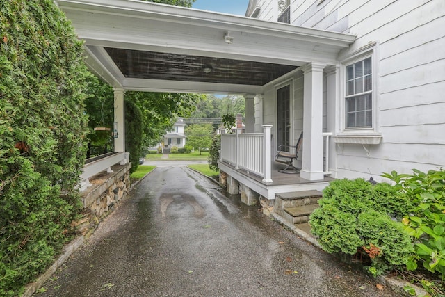 exterior space featuring aphalt driveway and covered porch