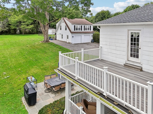 wooden terrace with stairs, a patio area, a yard, and a detached garage