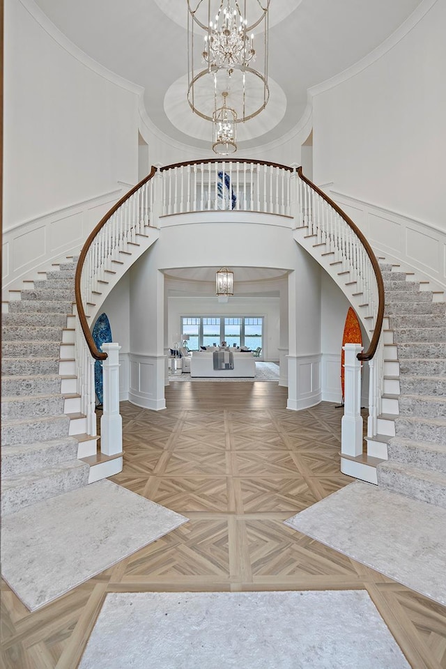 25 Brewster Ln, East Setauket, NY 11733 - entryway with a decorative wall, a chandelier, stairs, and wainscoting
