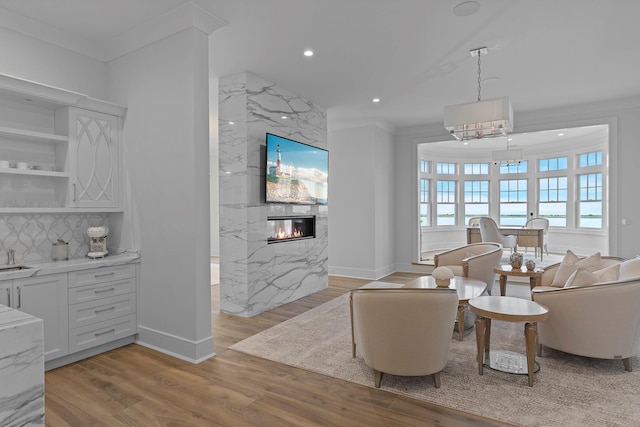 25 Brewster Ln, East Setauket, NY 11733 - living area with a fireplace, light wood-style floors, ornamental molding, recessed lighting, and baseboards