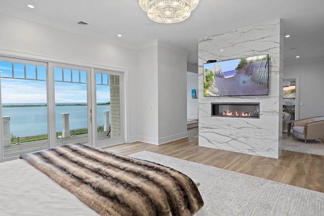 25 Brewster Ln, East Setauket, NY 11733 - bedroom with crown molding, a fireplace, wood finished floors, recessed lighting, and a chandelier
