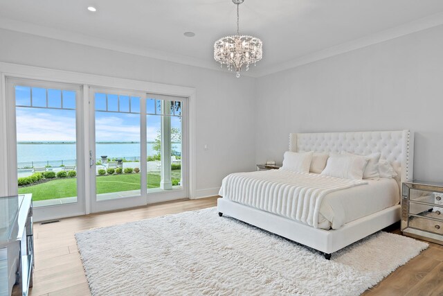 25 Brewster Ln, East Setauket, NY 11733 - bedroom featuring access to exterior, a water view, a chandelier, light wood-type flooring, and recessed lighting