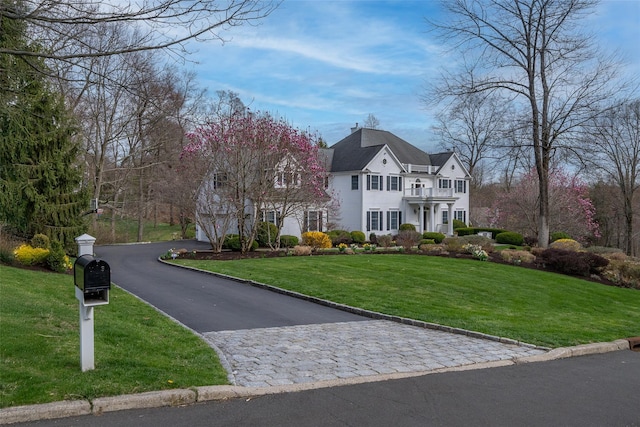 view of front of property with a front yard and a balcony