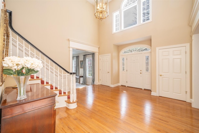 entrance foyer featuring stairway, a chandelier, and plenty of natural light