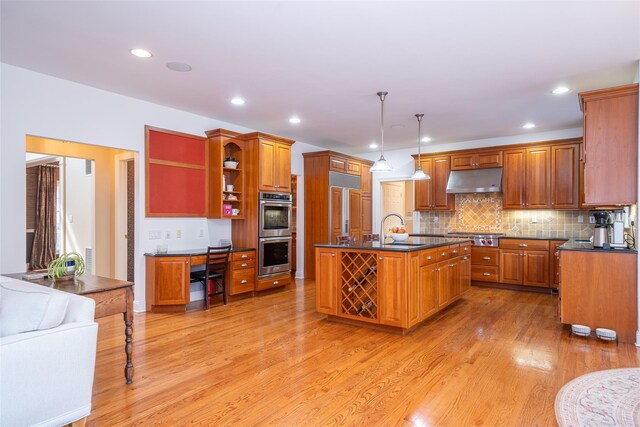 kitchen featuring dark countertops, open shelves, a sink, stainless steel appliances, and under cabinet range hood