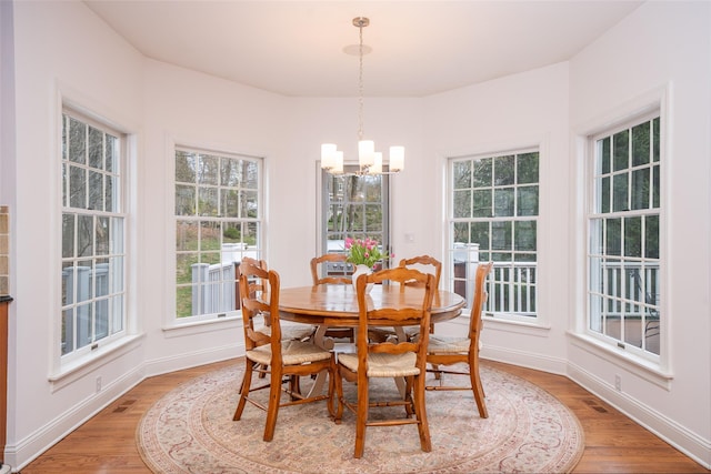 dining space featuring a chandelier, visible vents, light wood finished floors, and baseboards