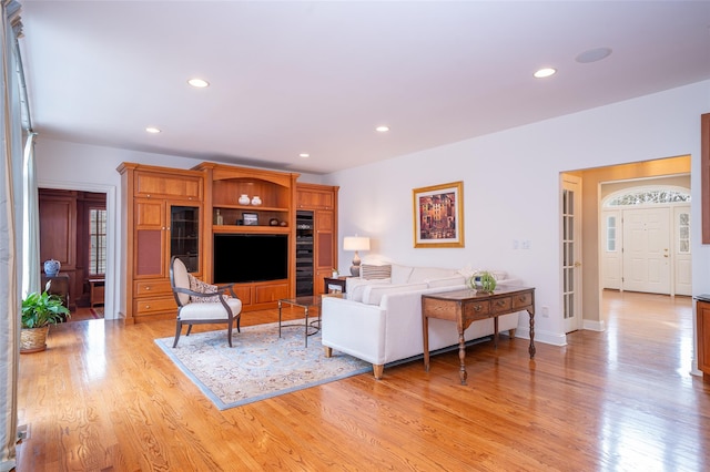 living area featuring baseboards, light wood finished floors, and recessed lighting
