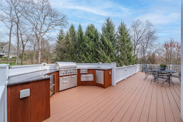 deck featuring outdoor dining area, an outdoor kitchen, and area for grilling