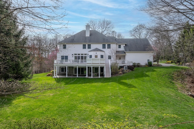 back of property featuring a chimney, a patio area, a lawn, stairway, and a deck
