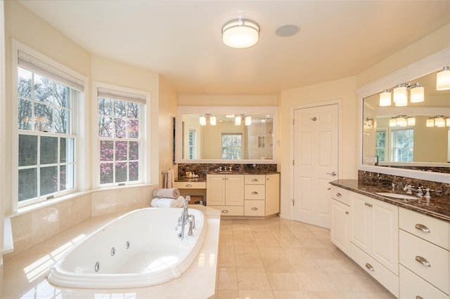 bathroom featuring a whirlpool tub, plenty of natural light, and a sink
