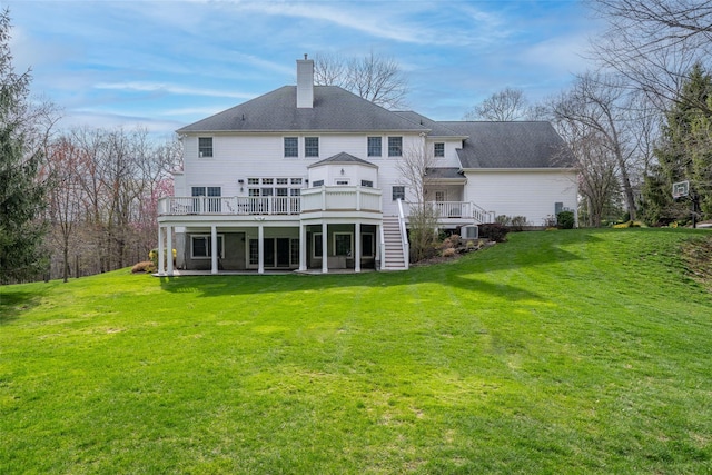 rear view of property with stairway, a chimney, a lawn, a deck, and a patio