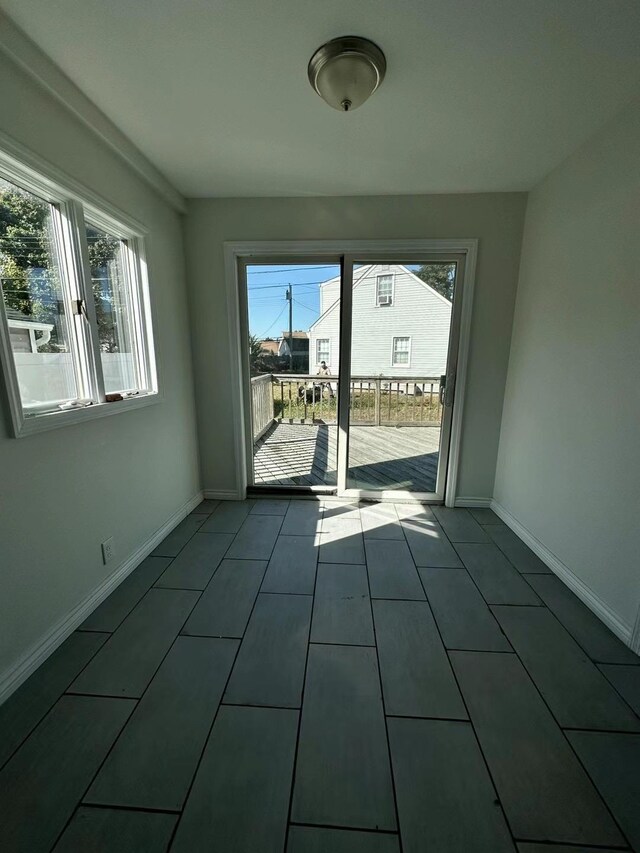 spare room featuring tile patterned floors and baseboards