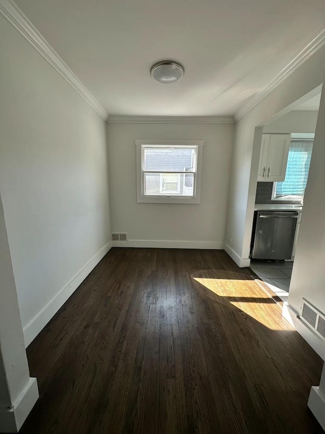 interior space featuring dark wood-type flooring, visible vents, baseboards, and ornamental molding