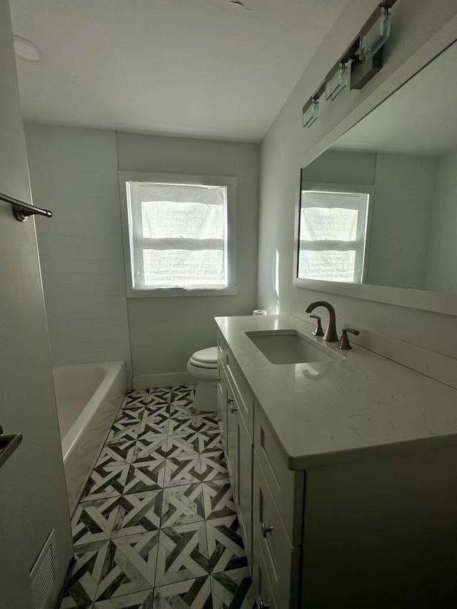 full bath featuring vanity, baseboards, a bathing tub, walk in shower, and toilet