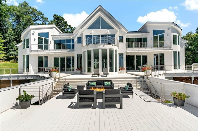 back of property with an outdoor hangout area, a deck, a balcony, and stucco siding