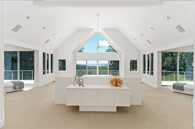 interior space with light carpet, visible vents, and high vaulted ceiling