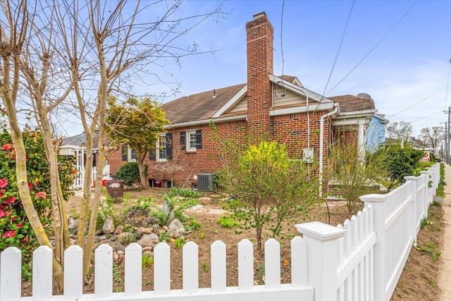 232 Courthouse Rd, Franklin Square, NY 11010 - exterior space featuring a chimney, brick siding, fence private yard, a shingled roof, and cooling unit