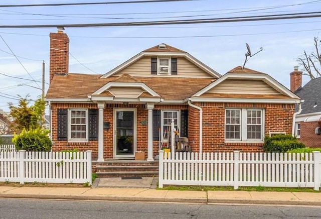 232 Courthouse Rd, Franklin Square, NY 11010 - view of front facade with a chimney, a fenced front yard, and brick siding