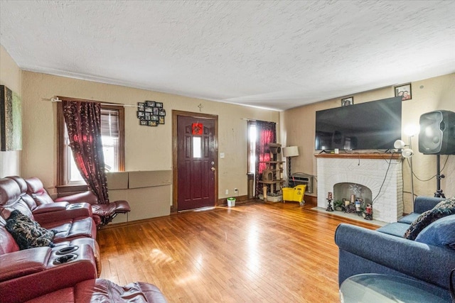 232 Courthouse Rd, Franklin Square, NY 11010 - living room featuring a brick fireplace, a textured ceiling, and wood finished floors
